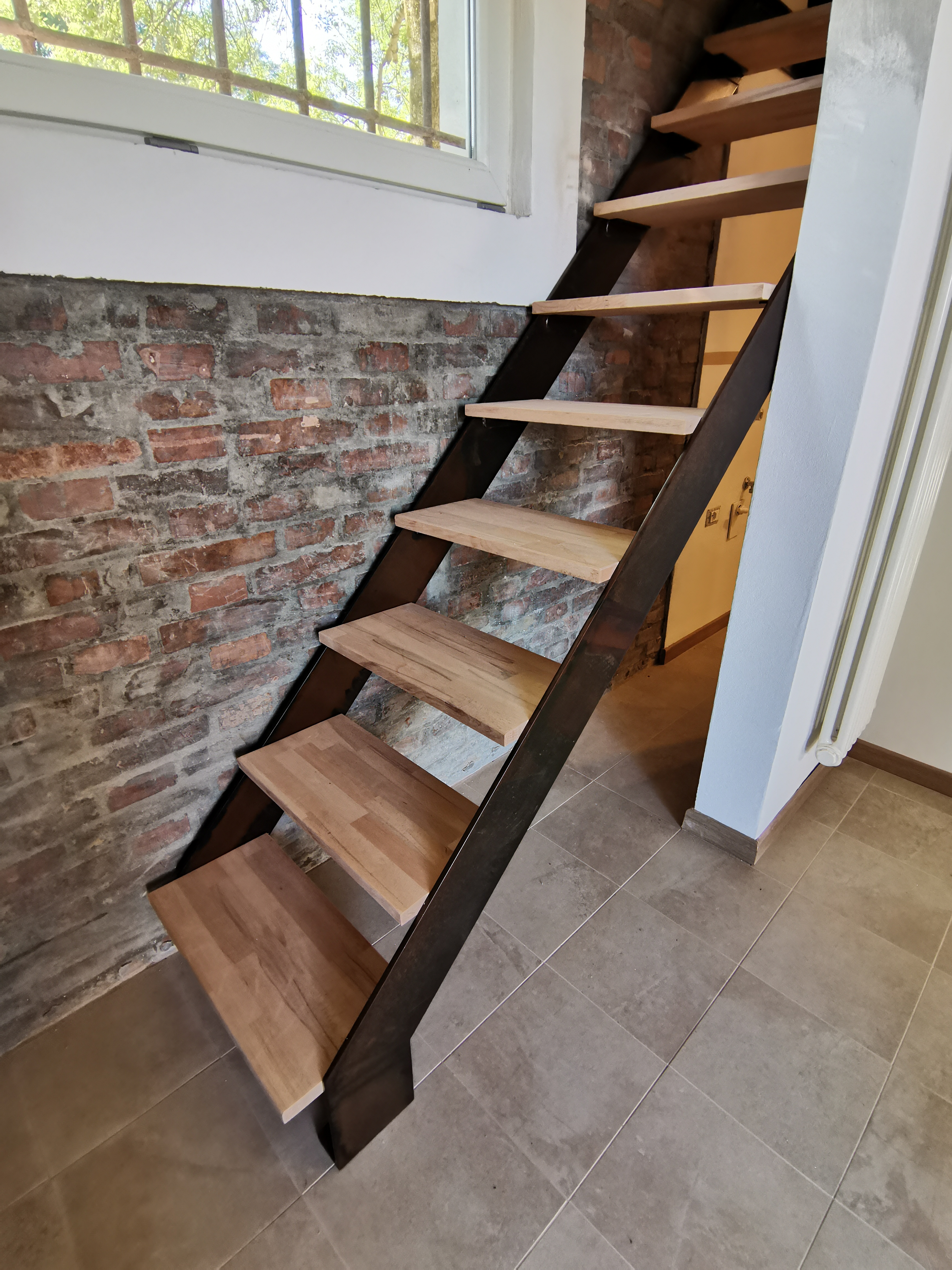 Scala realizzata in ferro ossidato e legno.